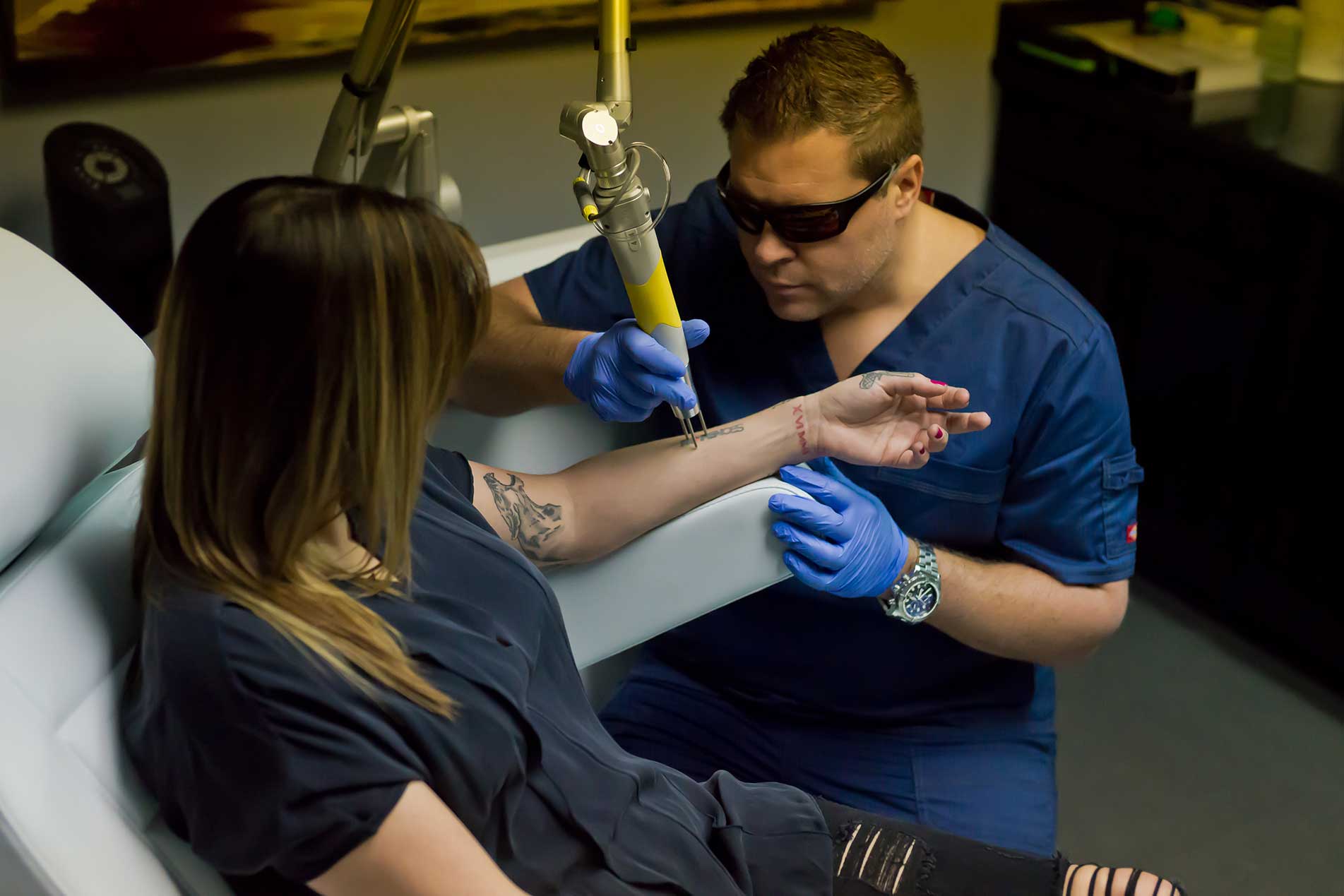 Ryan Wright running a laser tattoo removal treatment at Ink Blasters
